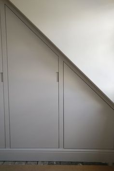 a white closet under a stair case in a room