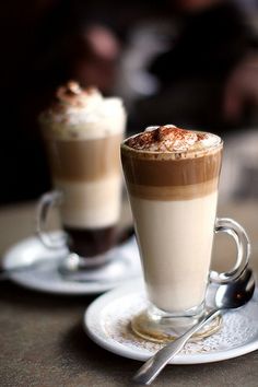 two cups of coffee sitting on top of a table