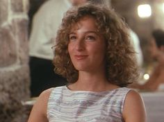 a woman with curly hair sitting in a restaurant