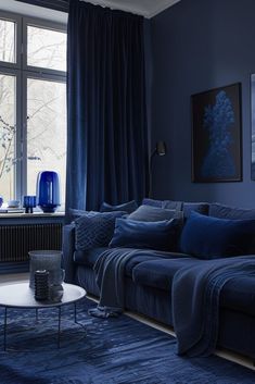 a living room filled with furniture and blue decorating on top of carpeted flooring