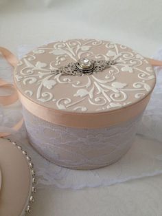 a white box sitting on top of a table next to a lace doily and ribbon