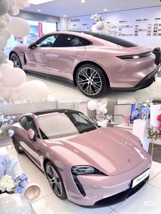 two pink sports cars parked in a showroom with balloons and flowers on the floor