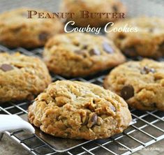 peanut butter and chocolate chip cookies cooling on a wire rack with the words, peanut butter cowboy cookies