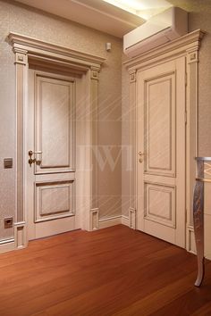 an empty room with wooden floors and white doors