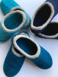 four pairs of blue and white slippers sitting on top of a table next to each other