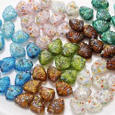 many different colored glass beads on a white plate