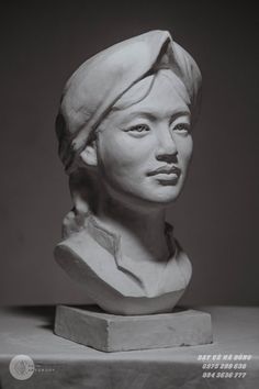 a black and white photo of a bust of a woman wearing a turban