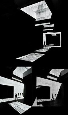 black and white photograph of people walking in an empty room with light coming through the windows