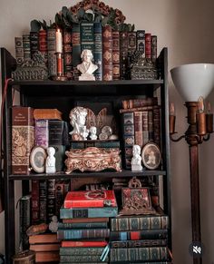 an old bookcase with many books and figurines sitting on top of it