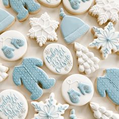 many decorated cookies on a table with snowflakes, mittens, and hats