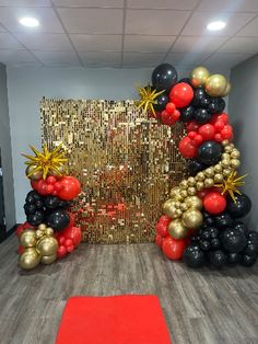 an entrance decorated with black, gold and red balloons for a corporate party or event