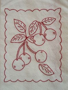 an embroidered piece of cloth with cherries on it