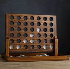 a wooden board game set with metal dots on the top and bottom, in front of a black background