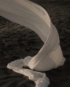 a white object laying on top of a sandy beach