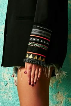 a woman's legs with colorful bracelets on them