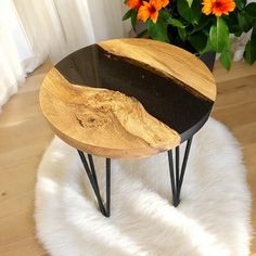 a wooden table sitting on top of a white rug next to a potted plant