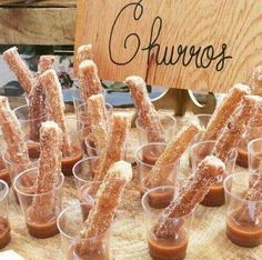 there are many small cups that have food in them on the table and one is filled with churros