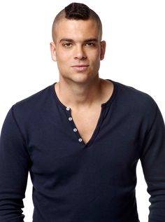 a man with a shaved head wearing a blue shirt