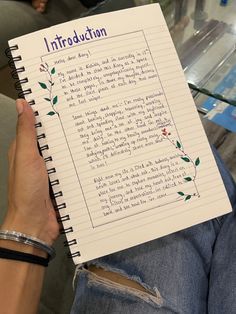 a person holding up a notebook with writing on it