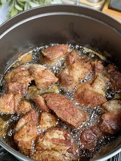 some meat is cooking in a pot on the stove