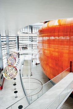 an orange object sitting on top of a white floor next to a stair case in a building