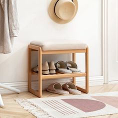 a wooden shoe rack with shoes on it next to a wall mounted hat rack and coat rack