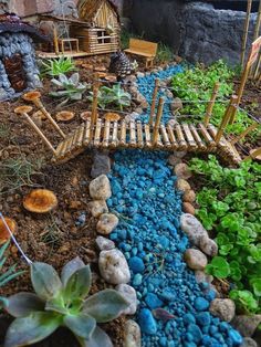 a small garden with rocks and plants in the center, along with a bridge made out of bamboo sticks