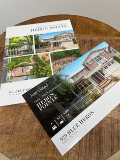 three real estate brochures sitting on top of a wooden table next to each other