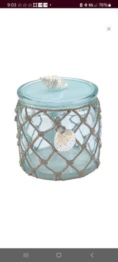 a glass jar with a sea shell inside it on a white background and an image of the lid