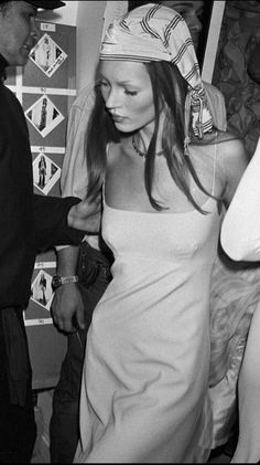 a black and white photo of a woman wearing a headdress at a party