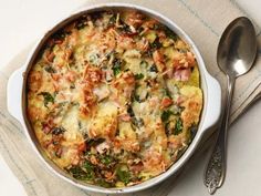 a casserole dish with spinach, ham and cheese in it next to a spoon