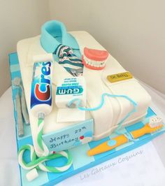 a birthday cake with toothbrushes, mouthpaste and dental floss on it