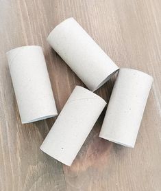 four rolls of toilet paper sitting on top of a wooden table