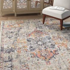 an area rug in a living room with a white chair and glass cabinet behind it