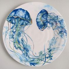 a blue and white plate with two jellyfishs on it