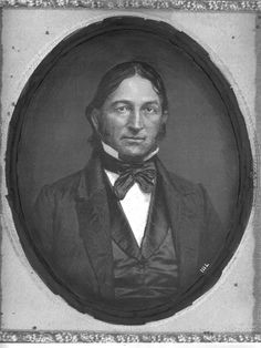 an old black and white photo of a man in a suit with a bow tie