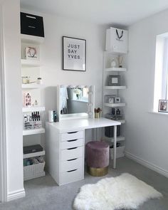 a white desk sitting under a window in a room