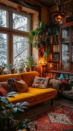 a living room filled with furniture and lots of plants on the windows sills