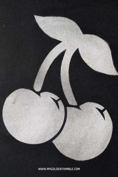 a drawing of two cherries on a black background