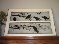 two birds are sitting on the branches of a tree in front of an old window