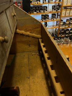 an old wooden boat in a store with shelves full of bottles on the wall behind it