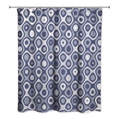 a shower curtain with blue and white circles on the outside, hanging from a metal rod