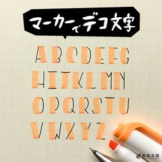 an orange and black pen sitting on top of a piece of paper with the letters written in japanese