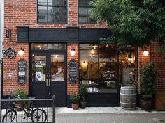 the outside of a restaurant with bikes parked in front of it and potted plants on the sidewalk