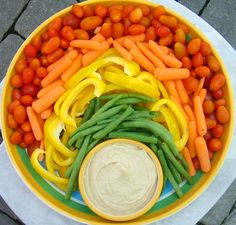 a yellow bowl filled with carrots and green beans