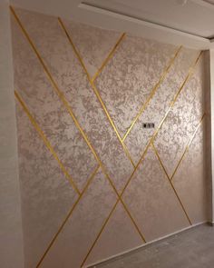 an empty room with gold lines painted on the wall