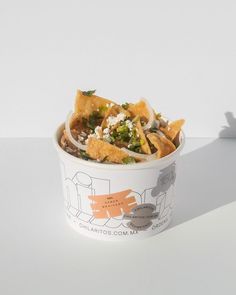 a bowl filled with nachos and cheese on top of a white countertop