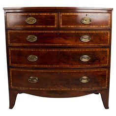 an antique chest of drawers with brass pulls and knobs on the top, against a white background