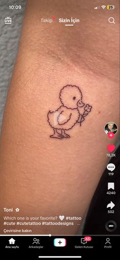 a small tattoo on the arm of a person with a duck in it's hand