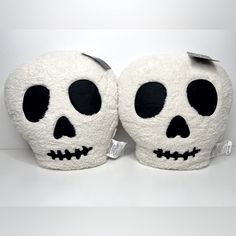 two white skulls with black eyes are sitting on a table